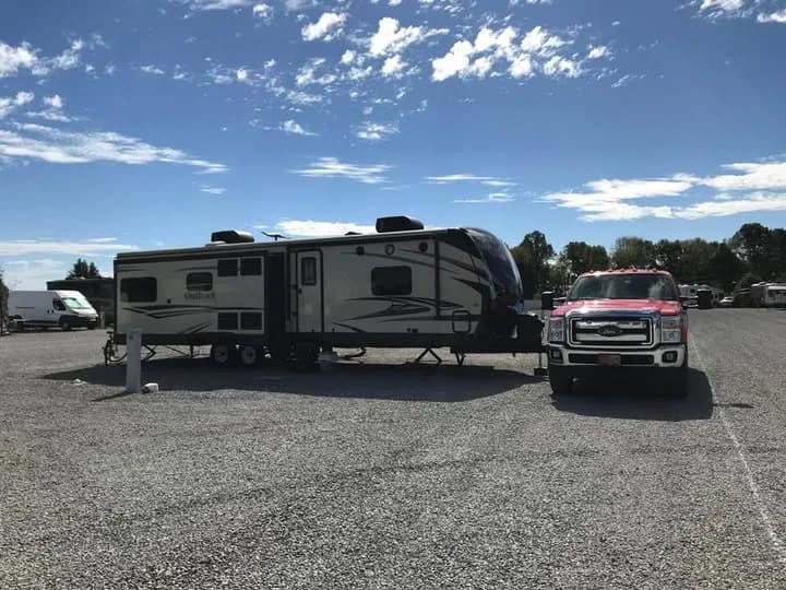 A travel trailer and pickup truck parked on a gravel site at Heartland RV Park
