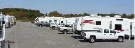 Row of RVs and pickup trucks parked at Heartland RV Park in autumn