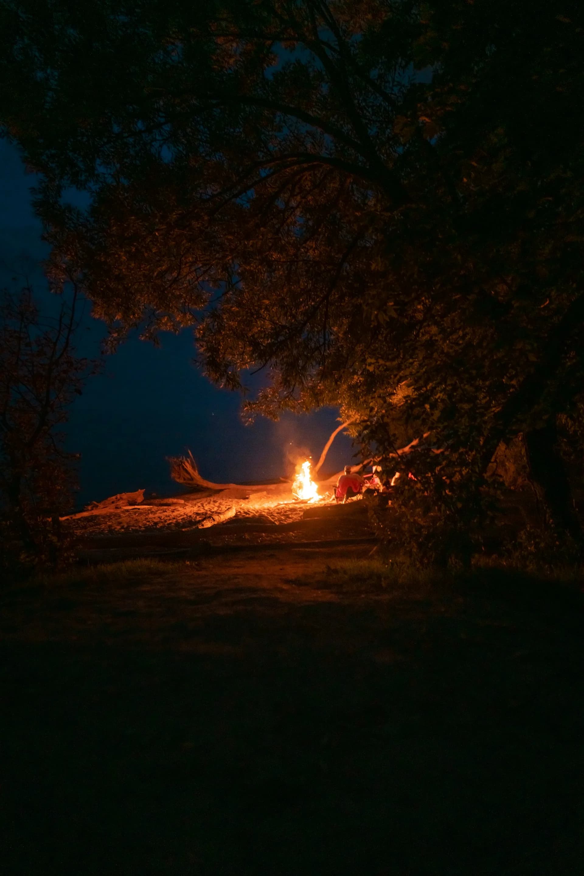 A warm communal campfire glowing at dusk at Heartland RV Park
