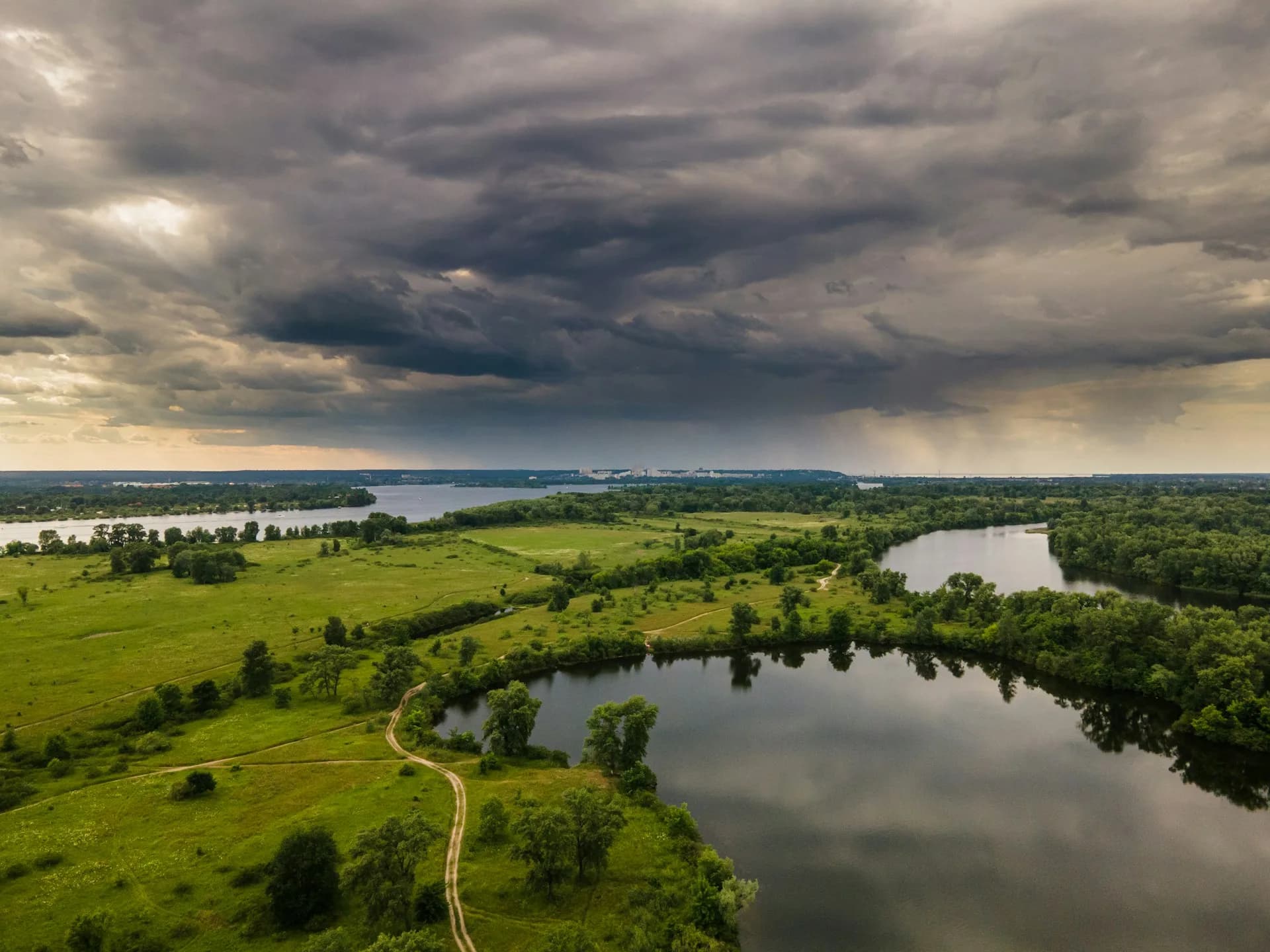 A wide Kentucky lake winding through green rolling fields at golden hour, near Green River Lake